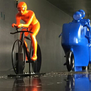 Image of computer simulations with colors depicting different pressure levels. The motorcycle follower causes an overpressure in front of it (red area) and a reduction in the low pressure behind the rider (blue area), thereby reducing the aerodynamic drag. Credit: TU Eindhoven.