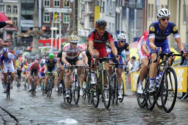 The bunch climb the famous Muur van Geraardsbergenmn in slippery and wet conditions. Image Eneco Tour / Cor Vos.