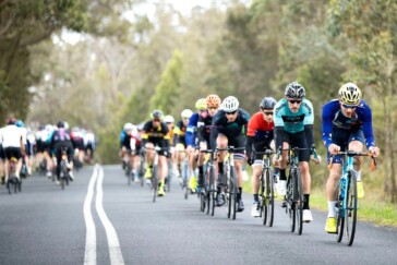 Megan Scott (white jersey) celebrates her Bowral Classic success with members of the Giant Sydney Cycling Club at the event village.